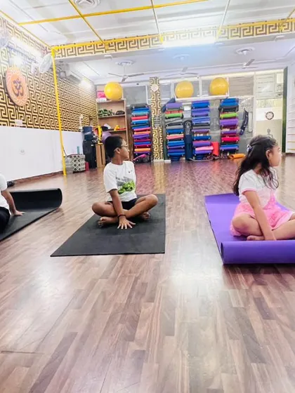 Children learning a gentle seated spinal twist. These poses are great for improving posture and keeping the spine healthy, especially for kids who spend time sitting at desks.