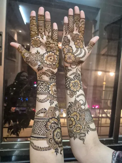 The same intricate floral design shown with palms open, highlighting the detailed work on the fingers and the beautiful flow from the palm to the arm.