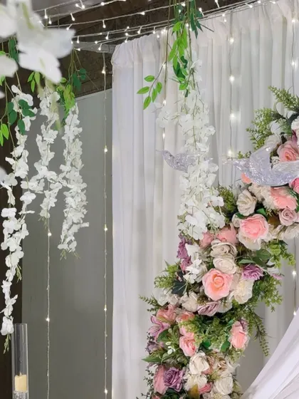 A close-up of the Nikah backdrop, showing the details of the hanging wisteria, decorative birds, and the soft glow of the fairy lights.