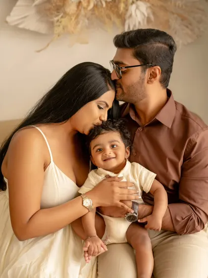 A beautiful family portrait filled with tender kisses. The parents shower their little one with affection, creating a photo that is overflowing with love.