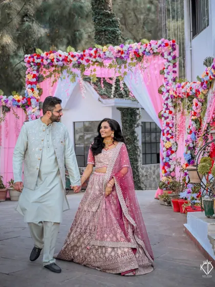 The couple walking hand-in-hand through the decorated entrance of their engagement venue.