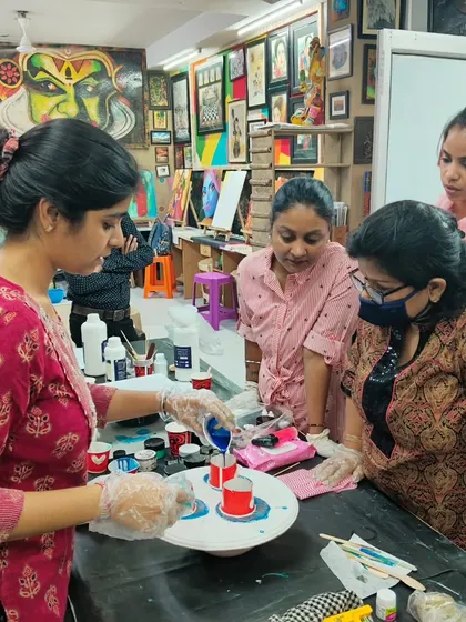 A student trying her hand at a dirty pour technique for fluid art. We encourage experimentation in a safe and supportive environment.