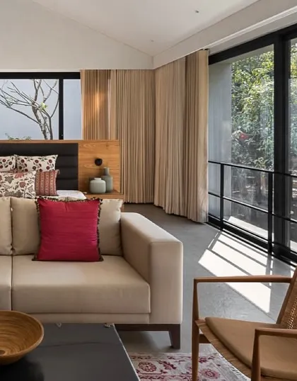 A bedroom should be a tranquil retreat. For the Mango Orchard House, we designed this master suite with floor-to-ceiling windows that open onto a private balcony, allowing our clients to wake up to the sights and sounds of their personal orchard.
