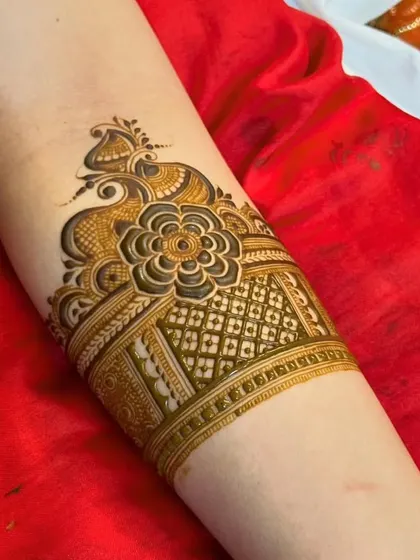An arm band combining a central flower with a geometric pattern.