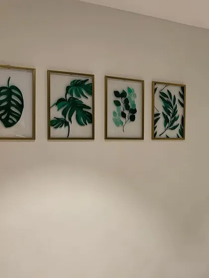 The set of four acrylic leaf paintings installed on a client's wall. They create a beautiful, cohesive gallery wall that feels both natural and sophisticated.