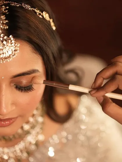 A close-up of the artistry involved. This shot captures the delicate process of applying eyeshadow, a crucial step in creating a flawless and blended look.