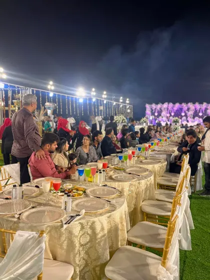 Guests seated and enjoying their meal at a large outdoor event.