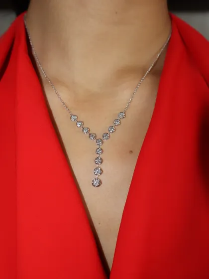 The Y-shaped diamond necklace on its own. Its simple yet brilliant design makes it a versatile piece that can be dressed up or down.