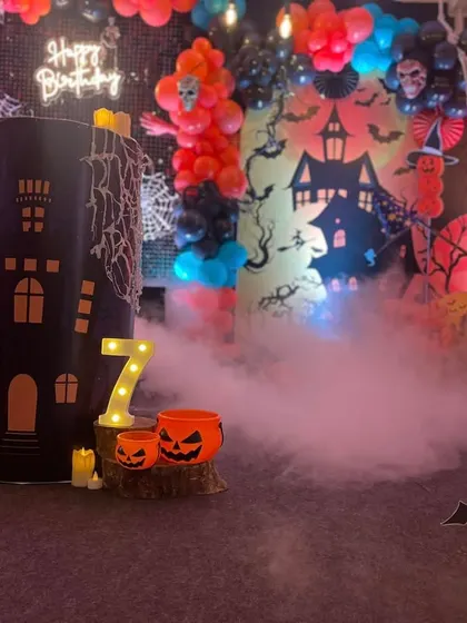 A closer look at the Halloween theme, featuring a dry ice effect for a foggy, mysterious atmosphere, along with spooky props like a ghost cutout and light-up pumpkins.
