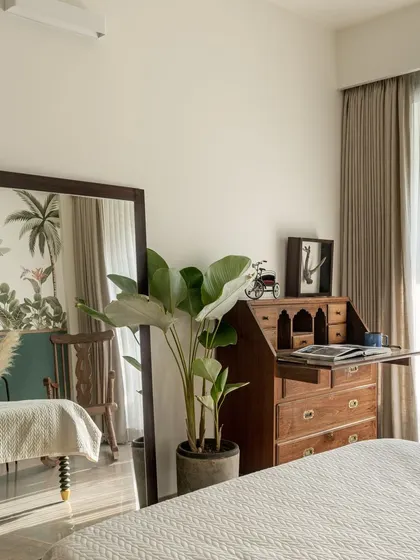 The reflection in the mirror shows how the tropical wallpaper wraps around the room, creating an immersive experience.