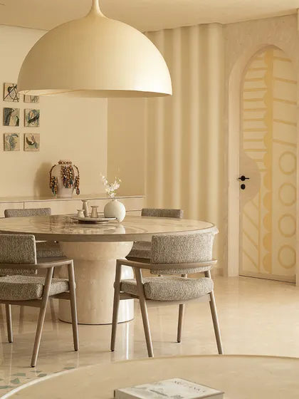 A detail of the dining area, showing the custom-designed door with yellow geometric patterns, adding a subtle pop of color to the otherwise neutral space.