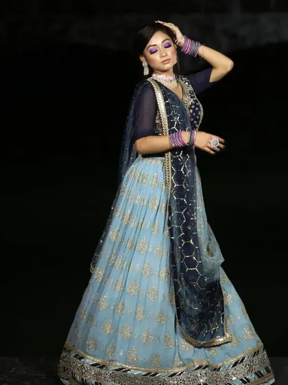 A dramatic pose in the blue lehenga, highlighting its beautiful design and flow. It's a picture-perfect outfit.