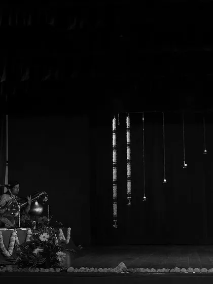 A black and white photo from my student's maiden Arangetram. It captures the grand scale of the stage, the live orchestra, and the solo dancer, a truly momentous occasion.