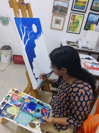 The initial stages of a monochromatic landscape, where the student blocks in the main shapes of the composition using deep blue acrylic paint.