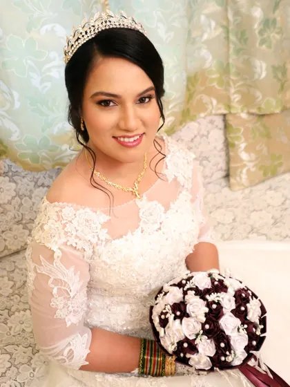 A portrait of a beautiful bride with a classic updo and a sparkling tiara. Her makeup features a soft smokey eye and a neutral pink lip, a timeless combination.