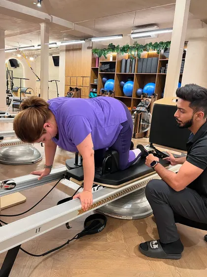 Change happens through movement, and movement heals. Our instructor provides support and guidance to a client working on the Reformer.