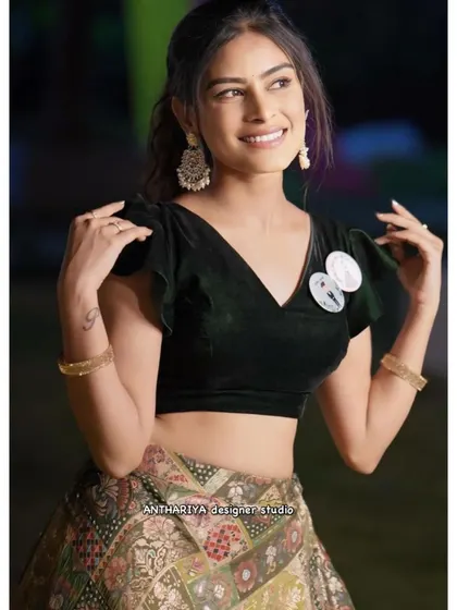 A close-up of a unique Indo-Western lehenga set, featuring a black velvet crop top and a printed skirt.