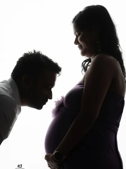 A classic silhouette of a father-to-be kissing the baby bump. It's a simple, yet profoundly moving image that speaks volumes about a parent's love.