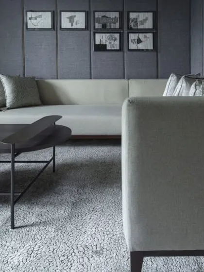The home theatre at the Jor Bagh Residence is designed for an immersive cinematic experience. The room features dark, acoustically treated wall panels, a large comfortable sofa, and controlled lighting to create the perfect viewing environment.