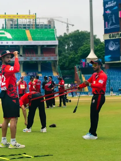 The team working with resistance bands during a warm-up. This helps activate the key muscles needed for explosive cricketing actions.