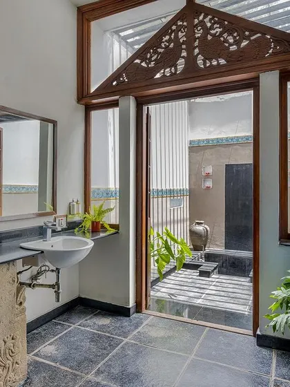 The Vasishta suite's bathroom, with its stone-carved vanity and view to a private courtyard, is a perfect example of our blend of rustic and refined.
