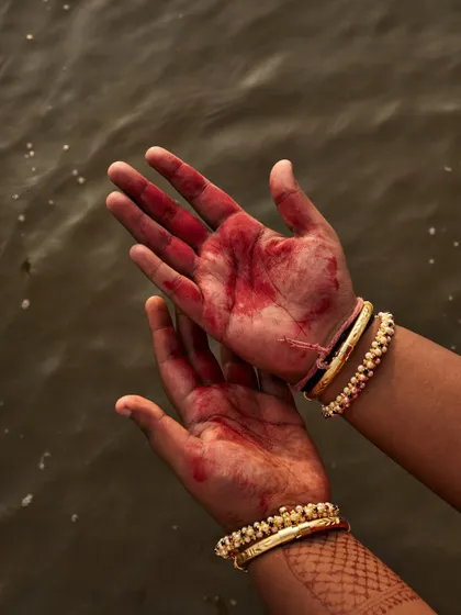 A close-up on the hands, stained with red, tells a story of its own. These detail shots add depth and poetry to a portrait series.