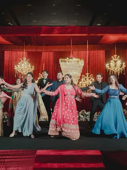 The whole family together for the final pose of their group performance. I help structure the entire sangeet show, including these big finale numbers.