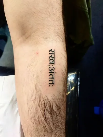 A simple yet profound script tattoo on the forearm. The clean Devanagari font ensures the message is clear and impactful.