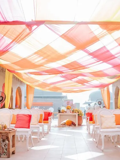 The ceiling of this walkway was decorated with a beautiful weave of orange, yellow, and pink drapes, creating a colorful canopy that bathed the space in warm, joyful light.
