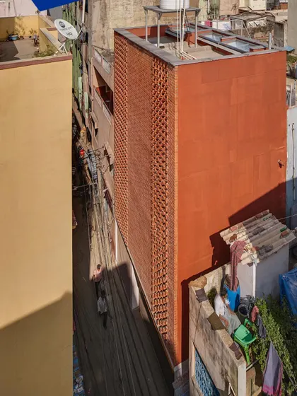 An aerial view of the 'Brick Weave House' in its dense urban context, where the solid brick form provides a private retreat.