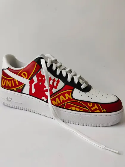 Another shot of the Manchester United Air Force 1s. The design wraps around the entire shoe, making a statement from every angle. Perfect for a true fan.