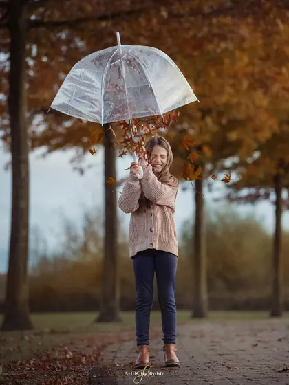 A creative and playful portrait of a girl using an umbrella to catch falling autumn leaves. It’s these fun, imaginative moments that make for unforgettable photos.