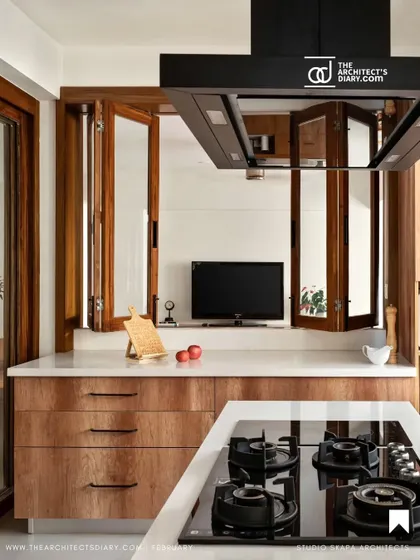 A featured shot of the kitchen, highlighting the island hob and the bifold pass-through window that connects to the family room, perfect for an owner who loves to cook and entertain.
