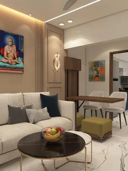 A living room design for a 1BHK in Mira Road, demonstrating efficient space planning. The layout includes a comfortable sofa, a compact coffee table, and a clear view into the adjacent kitchen area.
