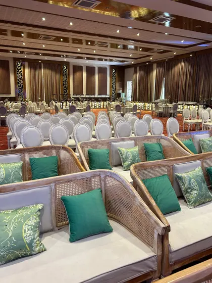 An overview of the guest seating arrangement, featuring elegant cane-backed sofas and classic chairs for a luxurious and comfortable experience.