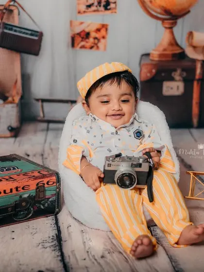 Posing with his camera, this little one is capturing memories of his own.