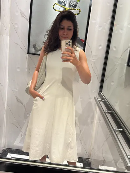 A simple and elegant all-white dress. This is a timeless piece that can be dressed up or down for any occasion, a true wardrobe staple.