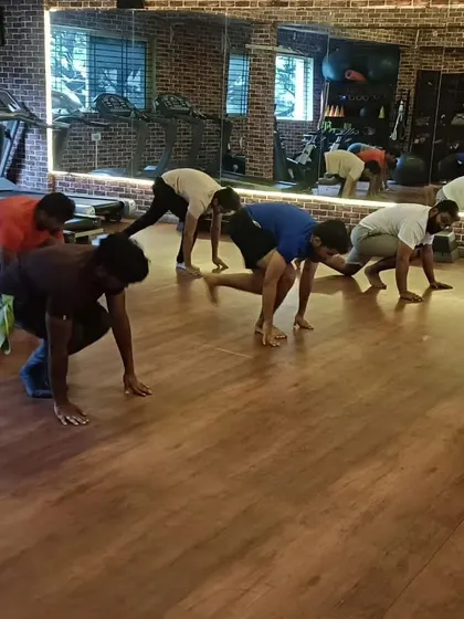 A dynamic shot of the class moving into a low lunge from a plank position, building strength and flexibility simultaneously.