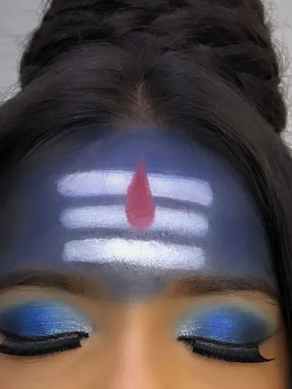 A close-up on the forehead for the Mahashivratri look, showing the clean lines of the 'tripundra' and the shimmer of the blue eyeshadow.