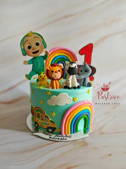 A colourful Cocomelon cake for a first birthday, featuring JJ, animal friends, and bright rainbows. A perfect theme for a toddler's party.