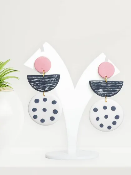 Modern, geometric earrings displayed on a clean white stand. This type of simple, well-lit photography is ideal for minimalist brands and online stores.