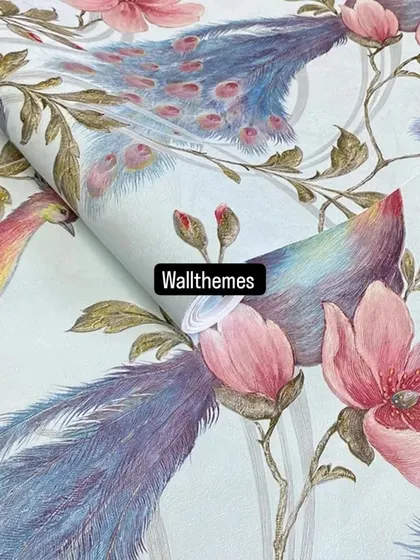 A close-up of a light blue wallpaper roll featuring a beautiful design of peacocks with blue and pink feathers.