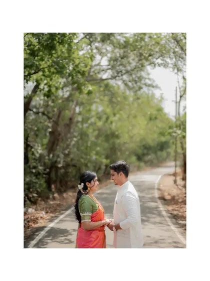 A wide shot of the couple standing on a road surrounded by trees, creating a sense of journey for their engagement story.