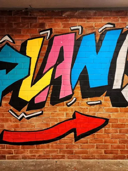 A close-up of the colorful graffiti-style "Plan B" logo we painted on a brick wall.