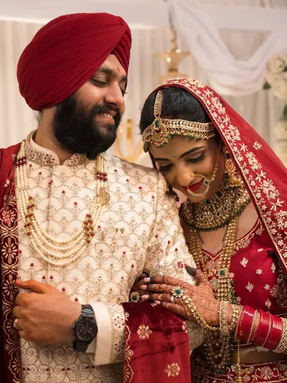 An intimate moment between the Sikh bride and groom, highlighting the intricate details of their wedding outfits and jewelry.