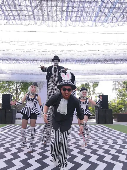 Performers bring our 'Line Art Carnival' theme to life. This concept blends the minimalist elegance of black and white line art with the vibrant energy of a carnival, complete with costumed entertainers and a striking checkered floor.