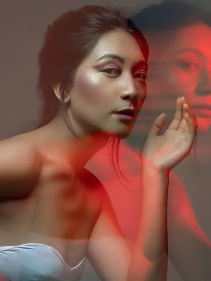 Playing with long exposure and light to create an ethereal, ghosting effect. The bold pink makeup still stands out, adding an artistic layer to this experimental portrait.