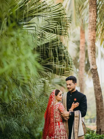 Framed by palm leaves, this portrait has a natural, intimate feel. The focus is entirely on the couple's connection, with the greenery adding a touch of tropical romance.