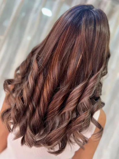 A beautiful blend of warm browns and sun-kissed blonde, creating major glow-up vibes with these perfectly styled curls.