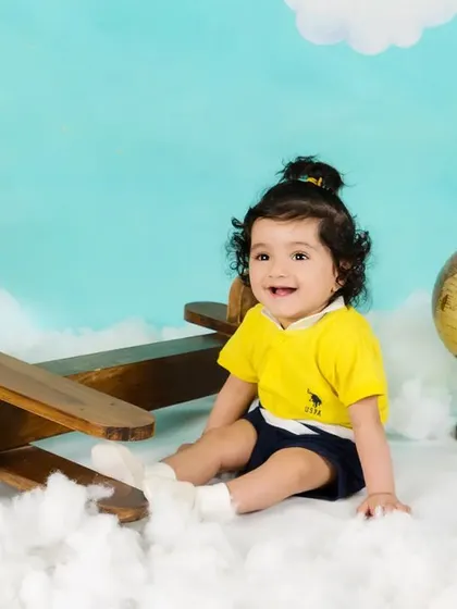 A smiling baby boy is ready for takeoff in his aviator-themed photoshoot.